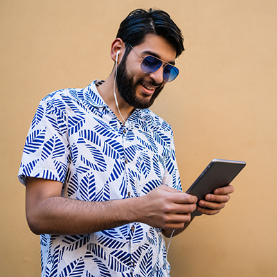Men 11 portrait young latin man using his digital tablet with earphones against yellow wall