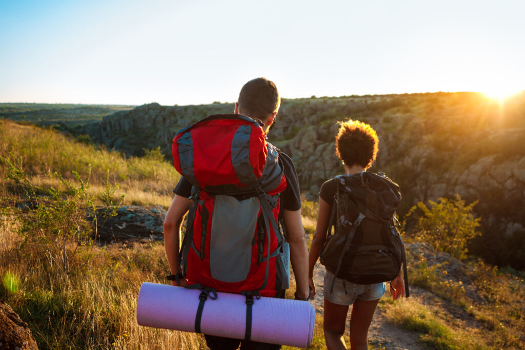 Men 9 young couple travelers with backpacks traveling canyon sunset 1